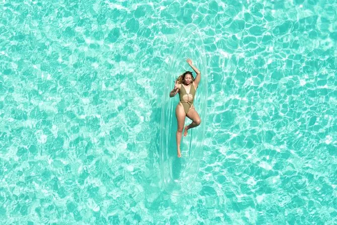 Aerial view of a guest posing in a transparent kayak in clear Caribbean water